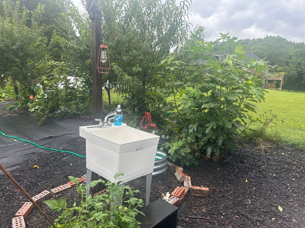 An outdoor wash station and hoses at the edge of the beds
